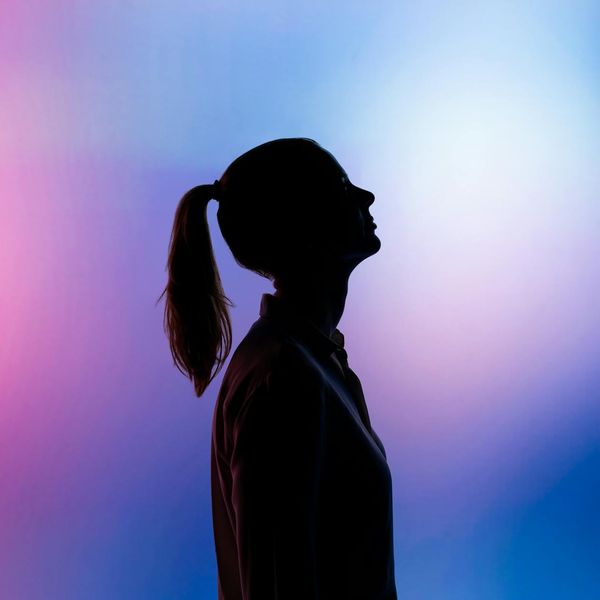 Silhouette of a person in a yoga pose against a calm background.